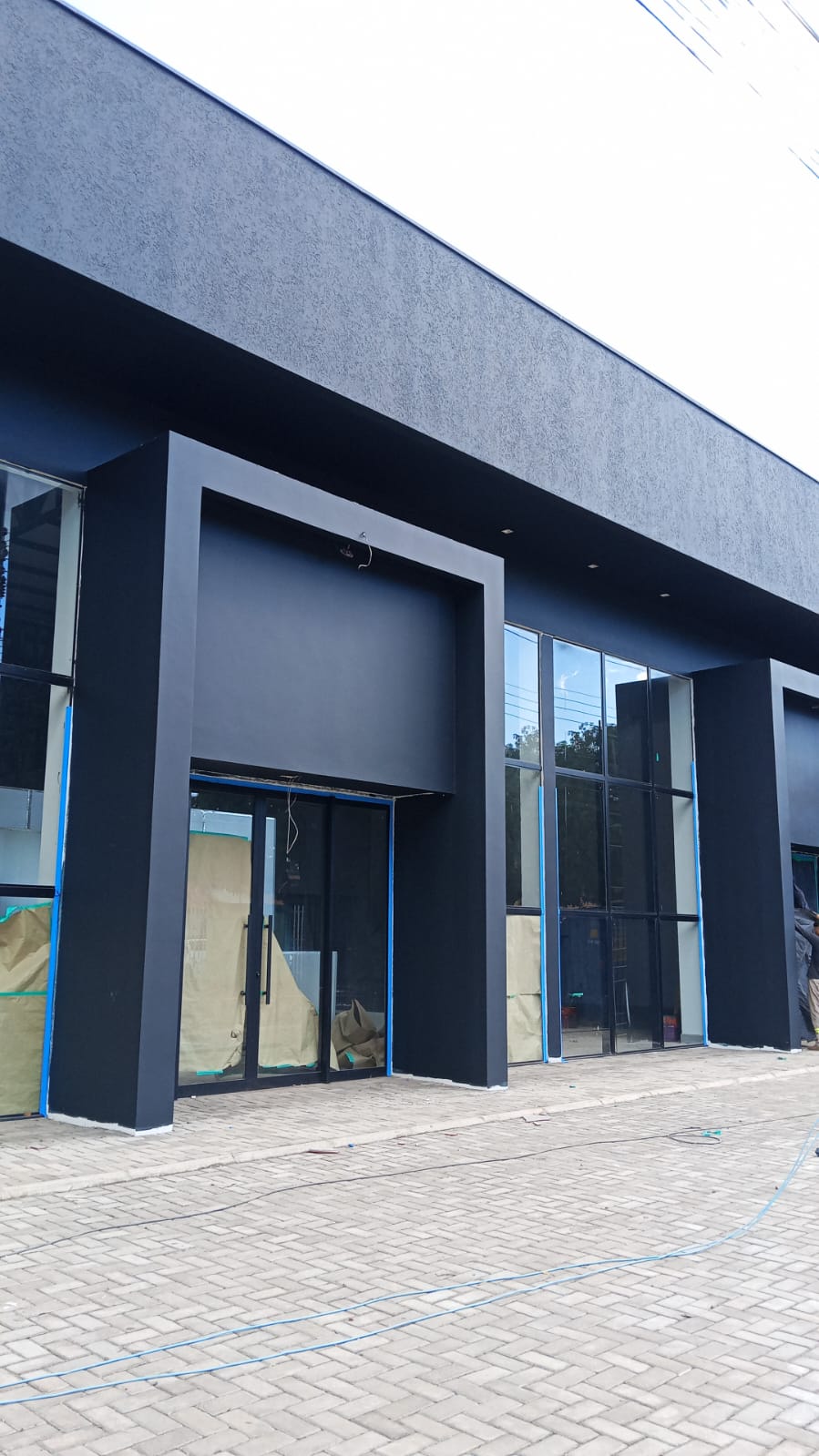 Fachada comercial recém-pintada em azul-marinho com vidraçaria